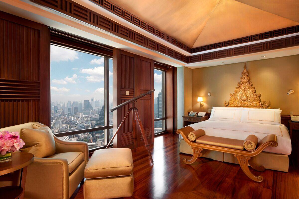 Ein Hotelzimmer mit Blick auf die Stadt, inklusive Bett, Schreibtisch und Stuhl.
