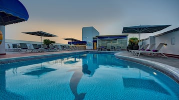 Piscine extérieure, parasols de plage, chaises longues