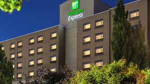 Edificio di un Holiday Inn Express dal design moderno, con un logo verde ben visibile e numerose finestre.