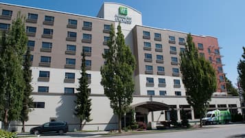 Ein Holiday Inn Express Hotel mit modernem Design, das ein Flachdach, viele Fenster und einen zentralen Eingang zeigt.