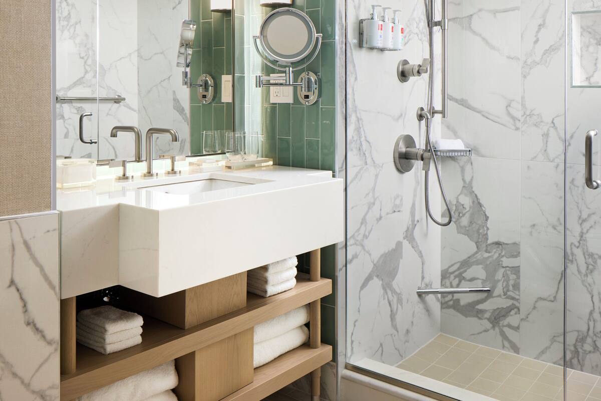 Une salle de bain moderne avec une douche à parois de verre, un meuble-lavabo et un miroir.