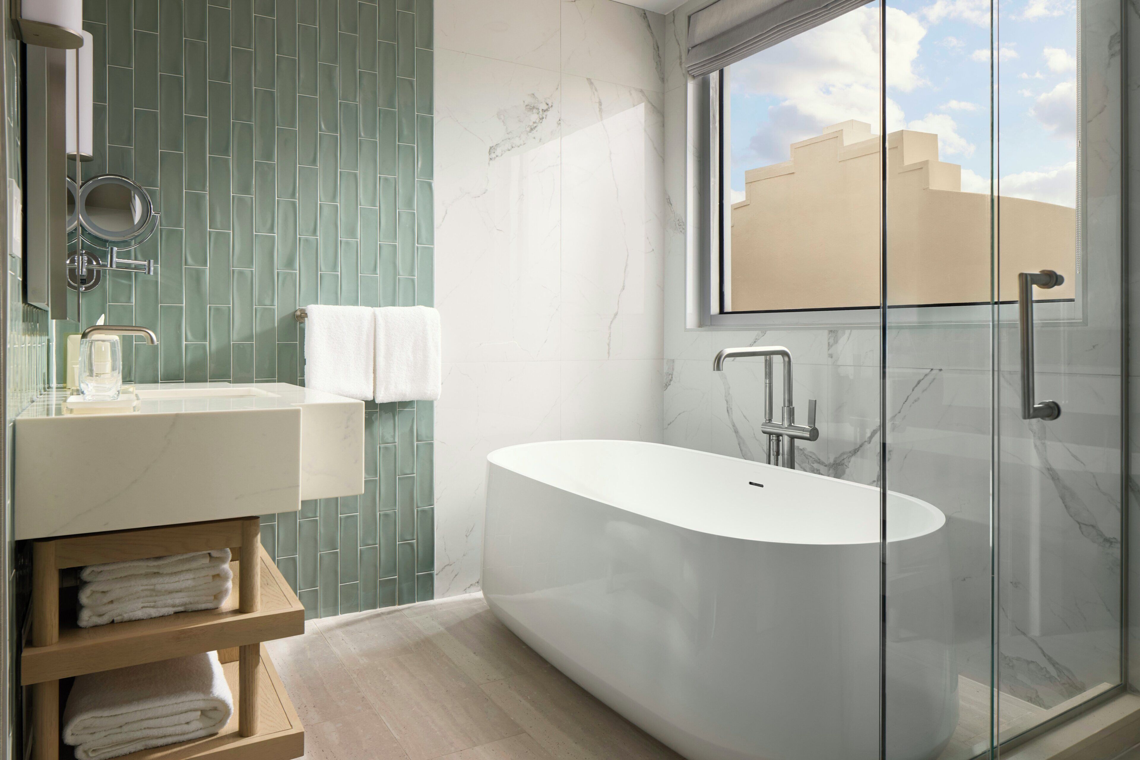 A modern bathroom with a freestanding bathtub, a vanity with a mirror, and a glass shower enclosure.