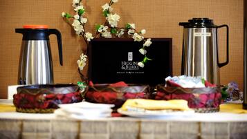 A table with a coffee maker, a teapot, and a decorative branch.