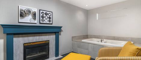 Un baño moderno con bañera, lavabo y chimenea.