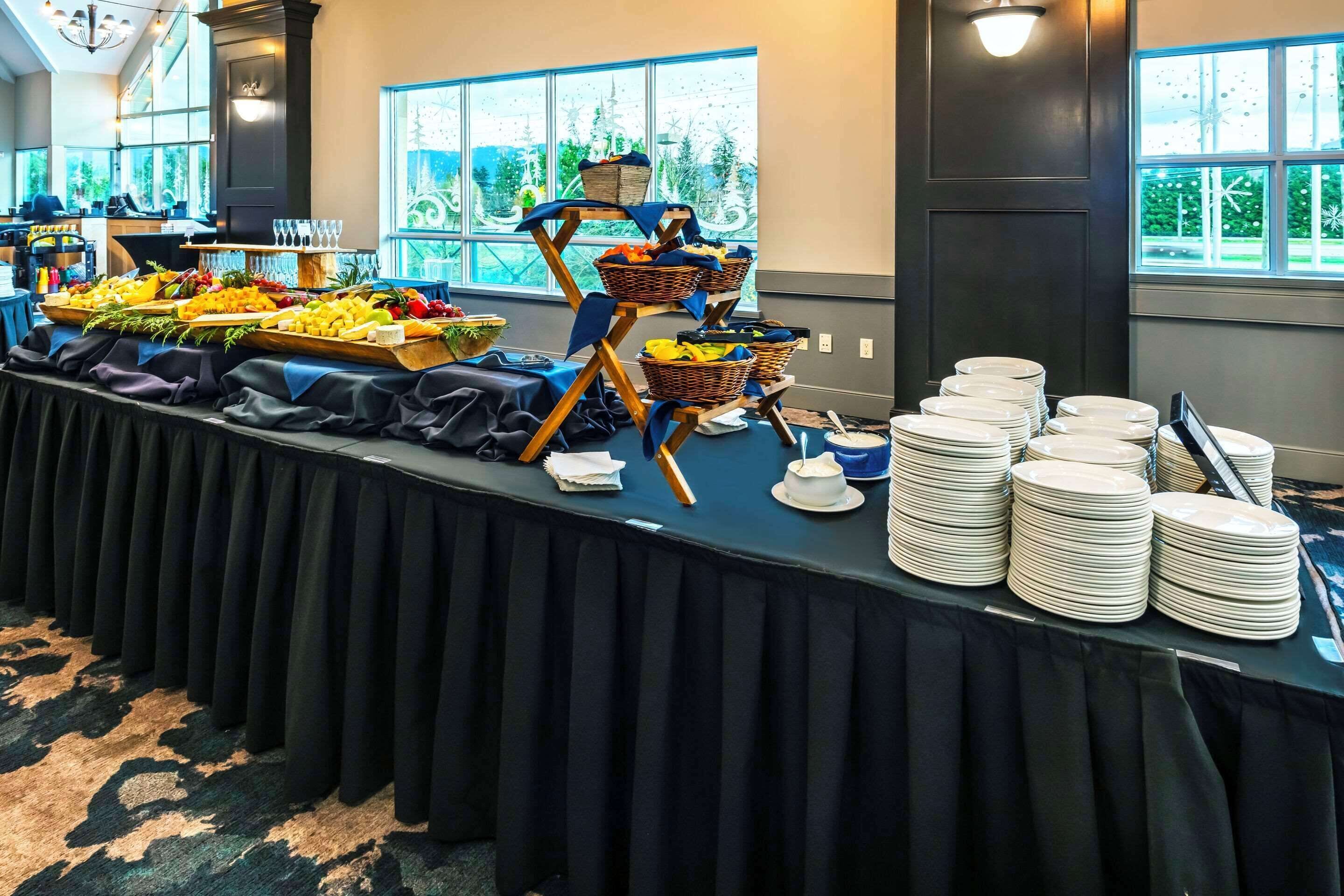 Un buffet proposant une variété de plats et où les assiettes sont empilées.