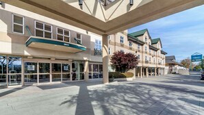 A hotel entrance with a glass facade, a green awning, and a parking area. - Clarion Hotel & Conference Centre Abbotsford  (Abbotsford)