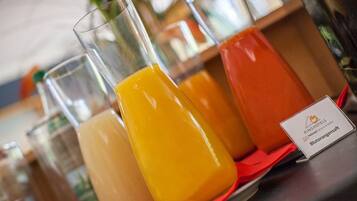 A table with three glasses of orange juice and a sign with hotel branding.