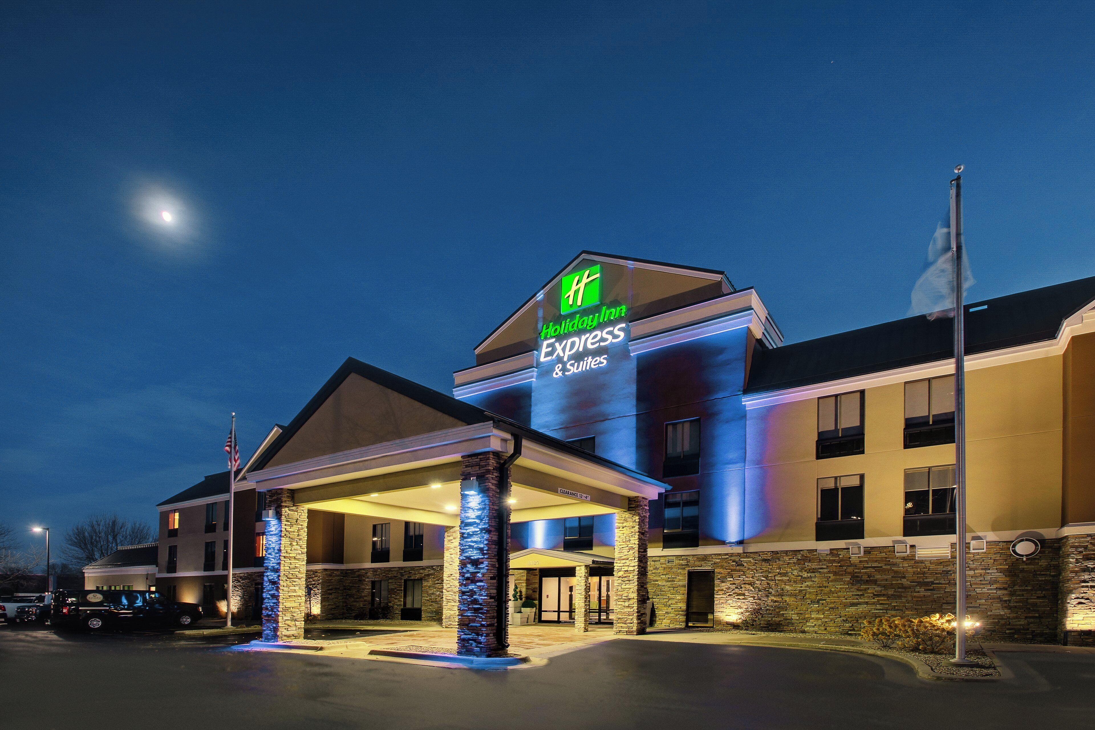 Un hotel Holiday Inn Express & Suites con fachada de piedra y entrada cubierta.