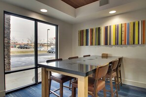 A conference room with a large table, chairs, and a view through the window. - Holiday Inn Express & Suites - Interstate 380 at 33rd Avenue by IHG (Cedar Rapids)