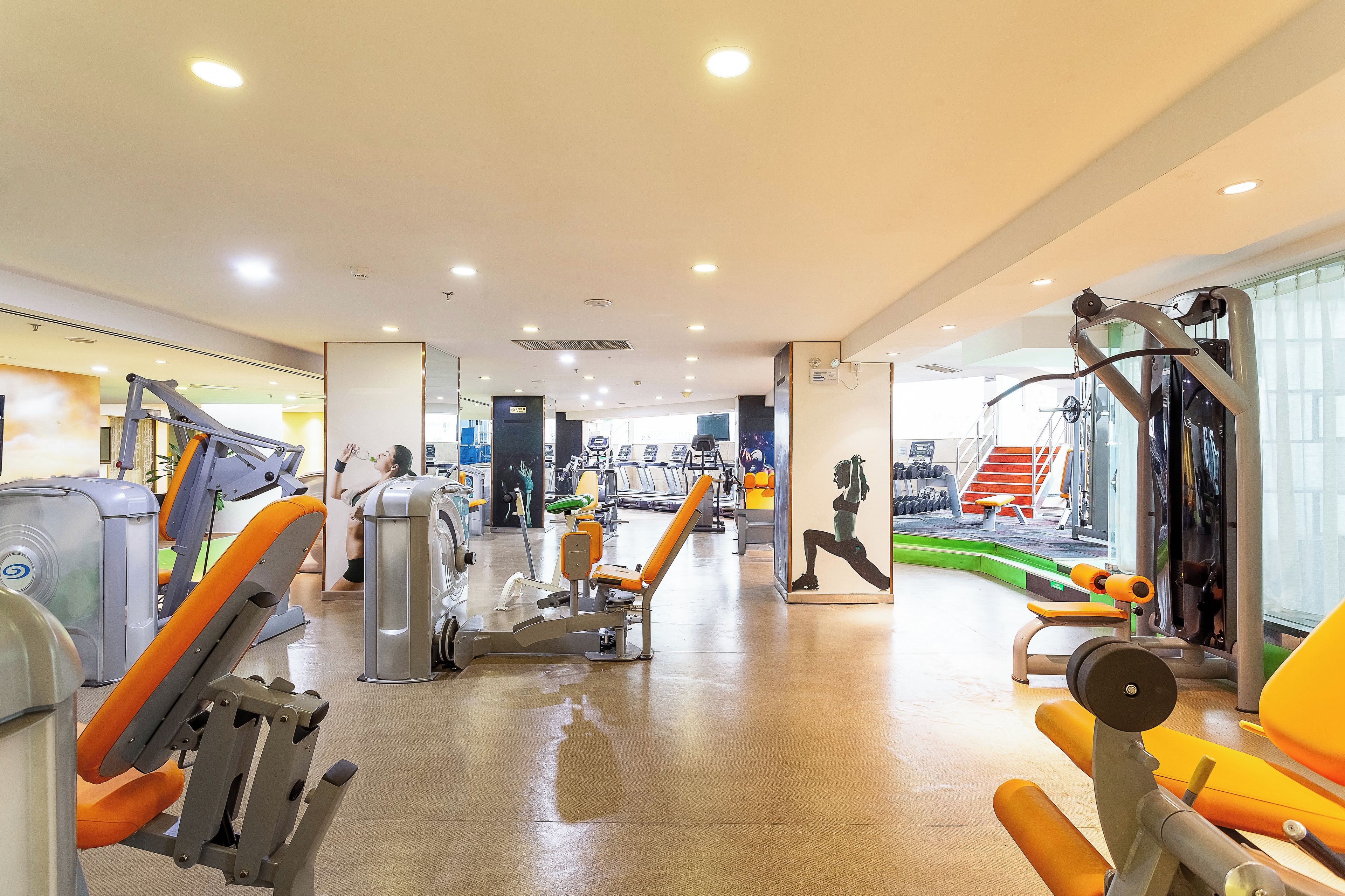 A gym with various exercise equipment, including treadmills and weight machines.