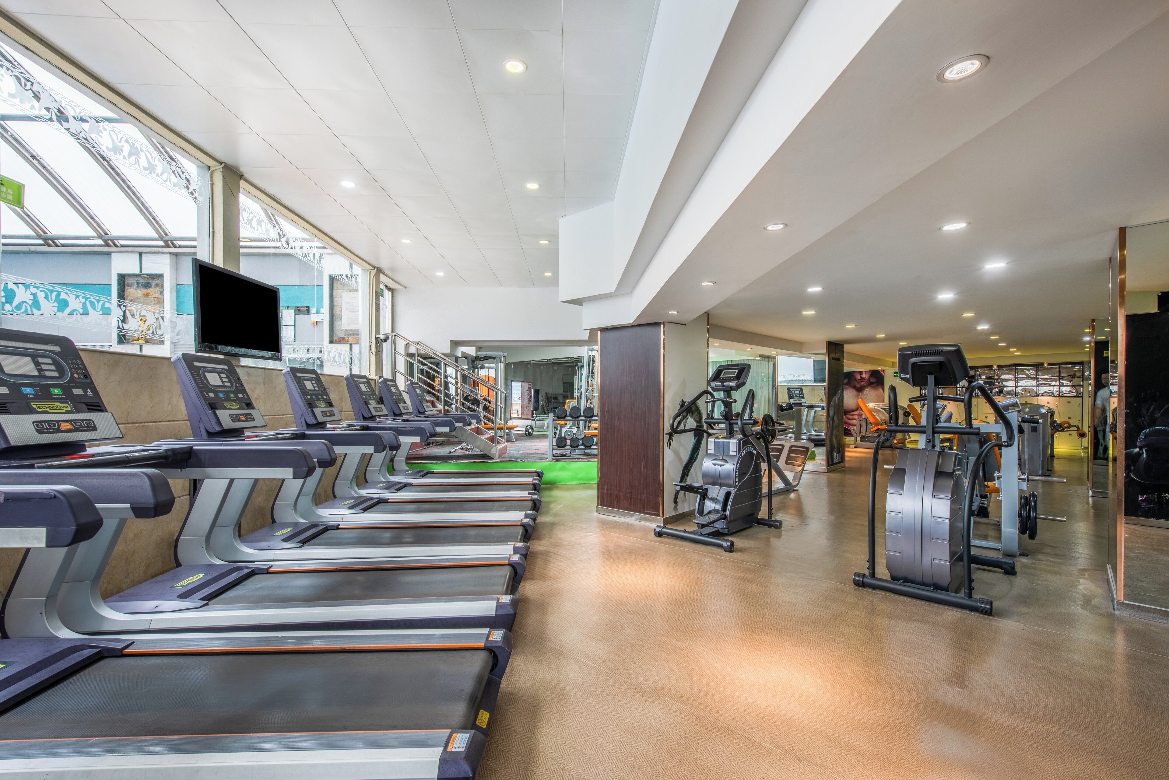A gym with treadmills, exercise bikes, and weight machines.