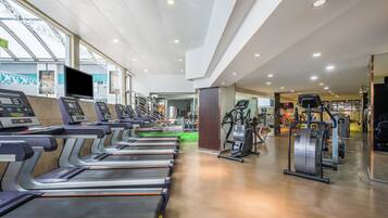 A gym with treadmills, exercise bikes, and weight machines.