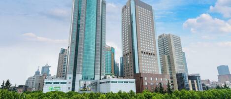 A cityscape with modern high-rise buildings, including a hotel with a prominent sign.