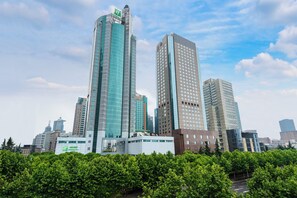 A cityscape with modern high-rise buildings, including a hotel with a prominent sign. - Holiday Inn Shanghai Pudong by IHG (Shanghai)