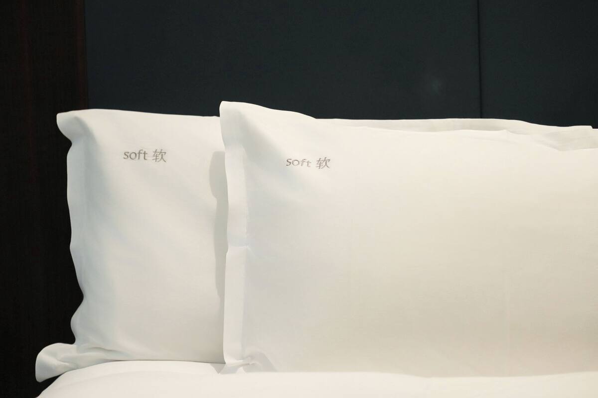 A bed with two pillows labeled "soft" and a dark background.