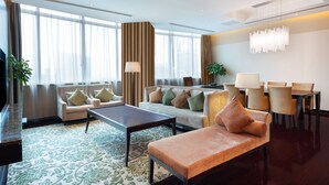 A modern hotel lobby with a sofa, chairs, a coffee table, and a TV. - Holiday Inn Shanghai Pudong by IHG (Shanghai)