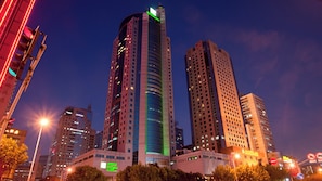 A high-rise building with a curved facade, surrounded by other tall buildings in an urban setting.