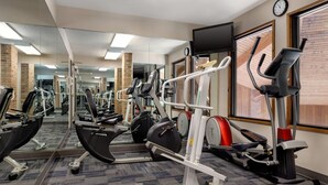 A gym with cardio machines, mirrors, and a clock on the wall. - Baymont by Wyndham Monroe (Monroe)