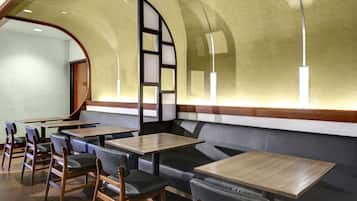 En restaurantindretning med båse, træborde og et buet loft.