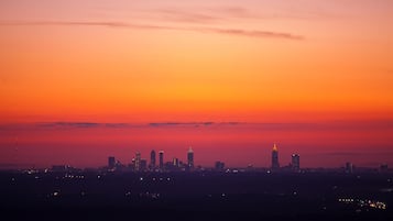 Un horizonte urbano al atardecer con edificios iluminados sobre un cielo degradado.