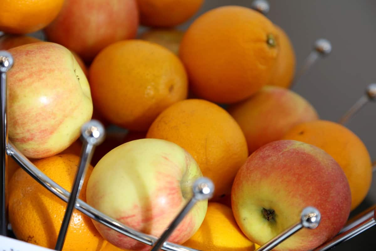 A fruit display with apples and oranges.