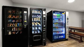 Drie automaten in een ruimte met een houten bank.