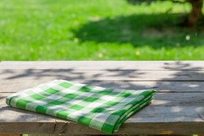 A neatly folded picnic blanket awaits on a table, set amidst lush surroundings.