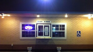 A building entrance with a sign reading "NIGHT WINDOW" and a wheelchair accessibility sign. - Newport News Inn (Newport News)
