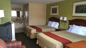 A hotel room with two beds, a desk, a chair, a TV, a bathroom, and a painting on the wall. - Newport News Inn (Newport News)