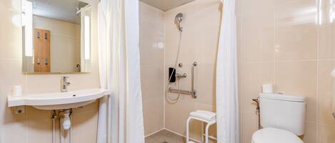 Un baño con lavamanos, inodoro, ducha y espejo.