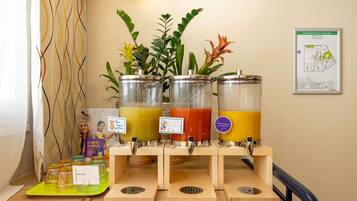 A juice bar with three dispensers, a map on the wall, and a plant in the background.