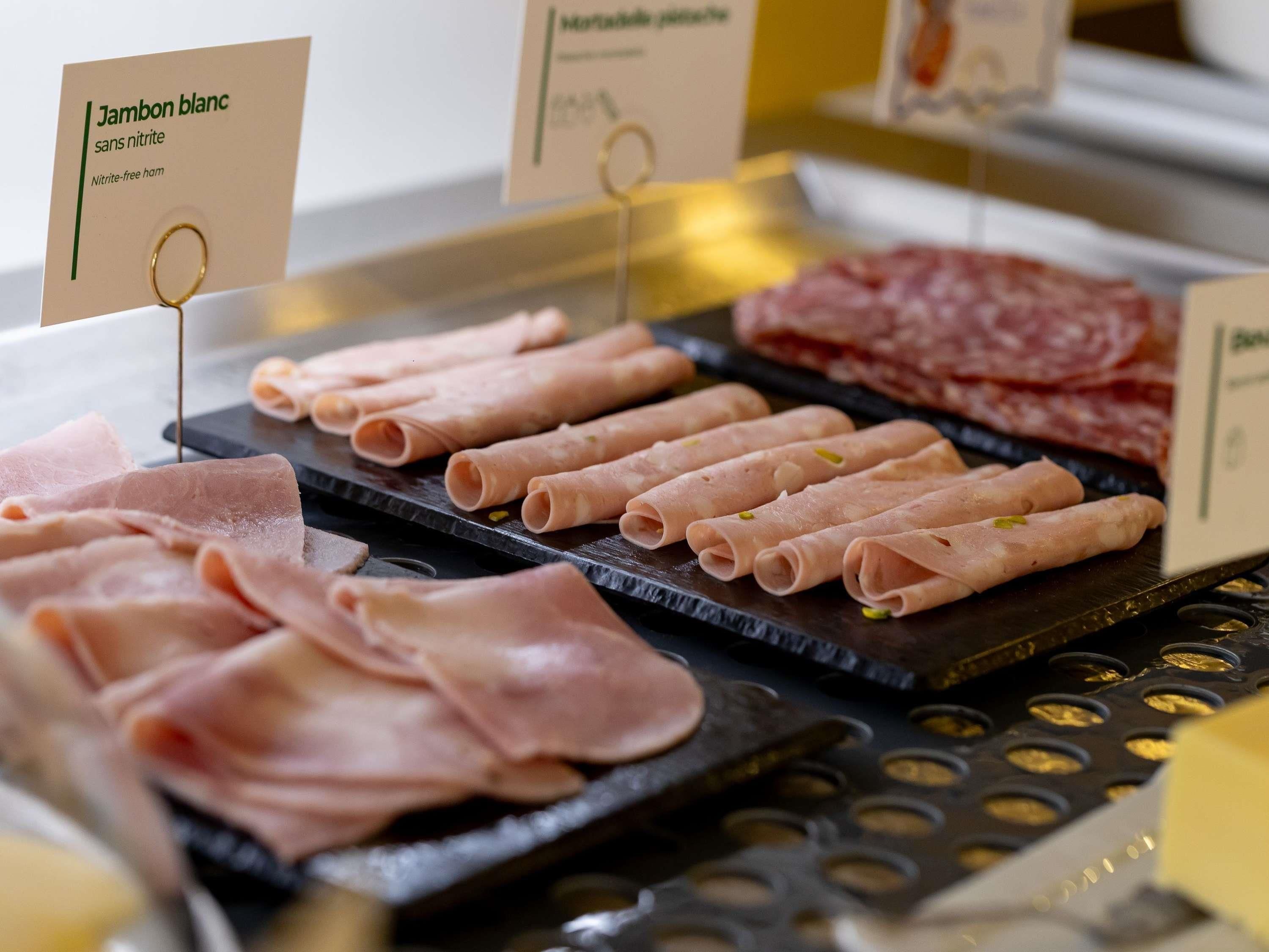 A selection of meats including Jambon blanc and other types, displayed on a counter.