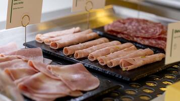 A selection of meats including Jambon blanc and other types, displayed on a counter.