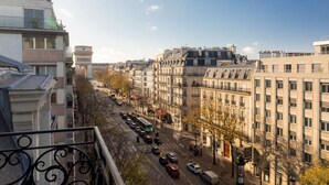 A city street with buildings, a tram, and a clear sky. - Hotel Elysées Céramic (Paris)