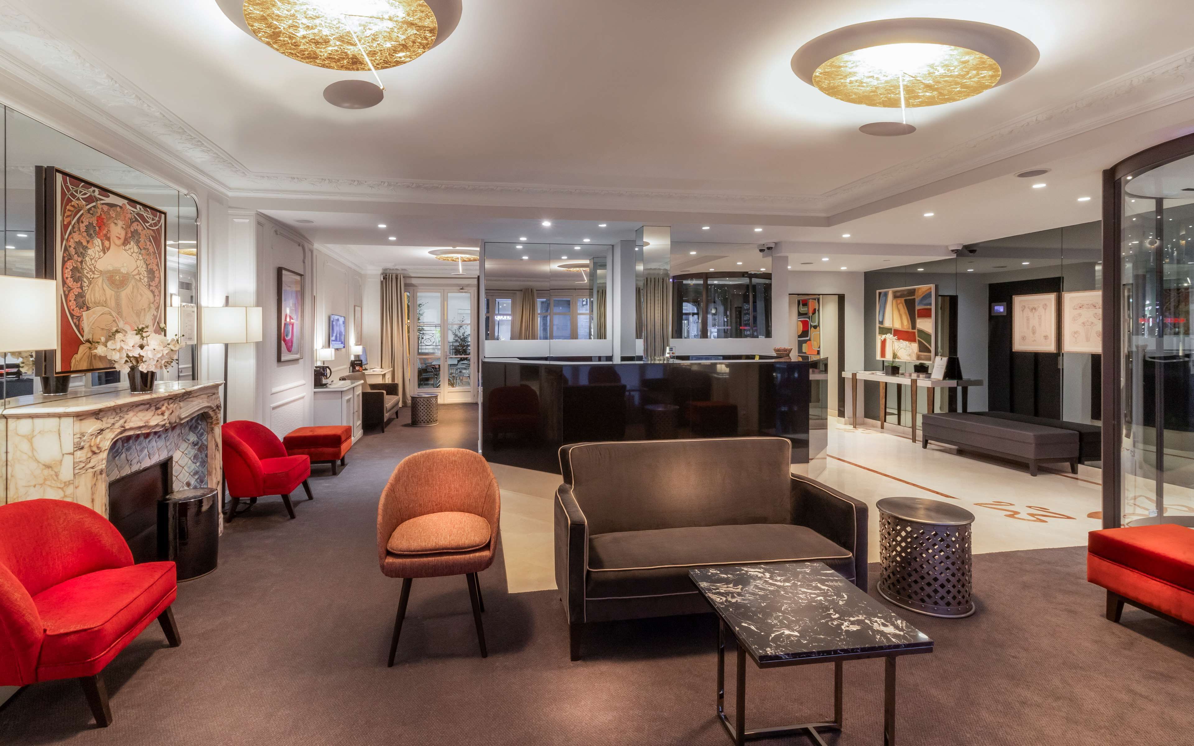 Un hall d’hôtel moderne doté d’une cheminée, d’un espace salon et d’un comptoir d’accueil.