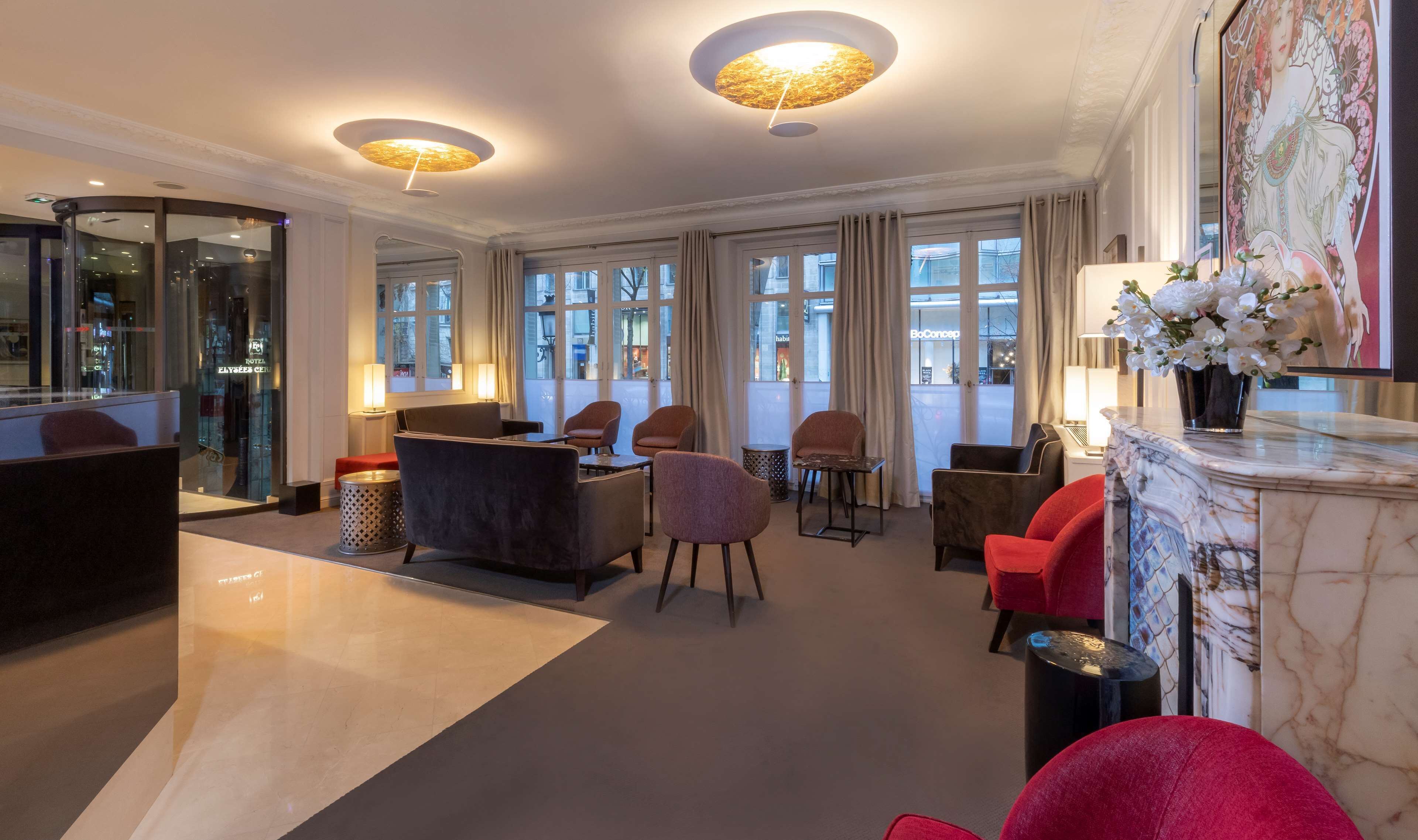 A spacious lobby with multiple seating areas, large windows, and modern lighting fixtures.