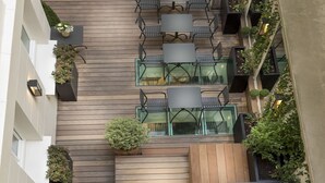 A courtyard with outdoor seating, a staircase, and potted plants. - Hotel Elysées Céramic (Paris)