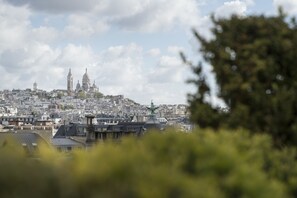 A cityscape with a prominent church and a statue in the foreground. - Hyatt Paris Madeleine (Paris)