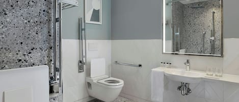 A modern bathroom with a white toilet, a sink, and a shower area.