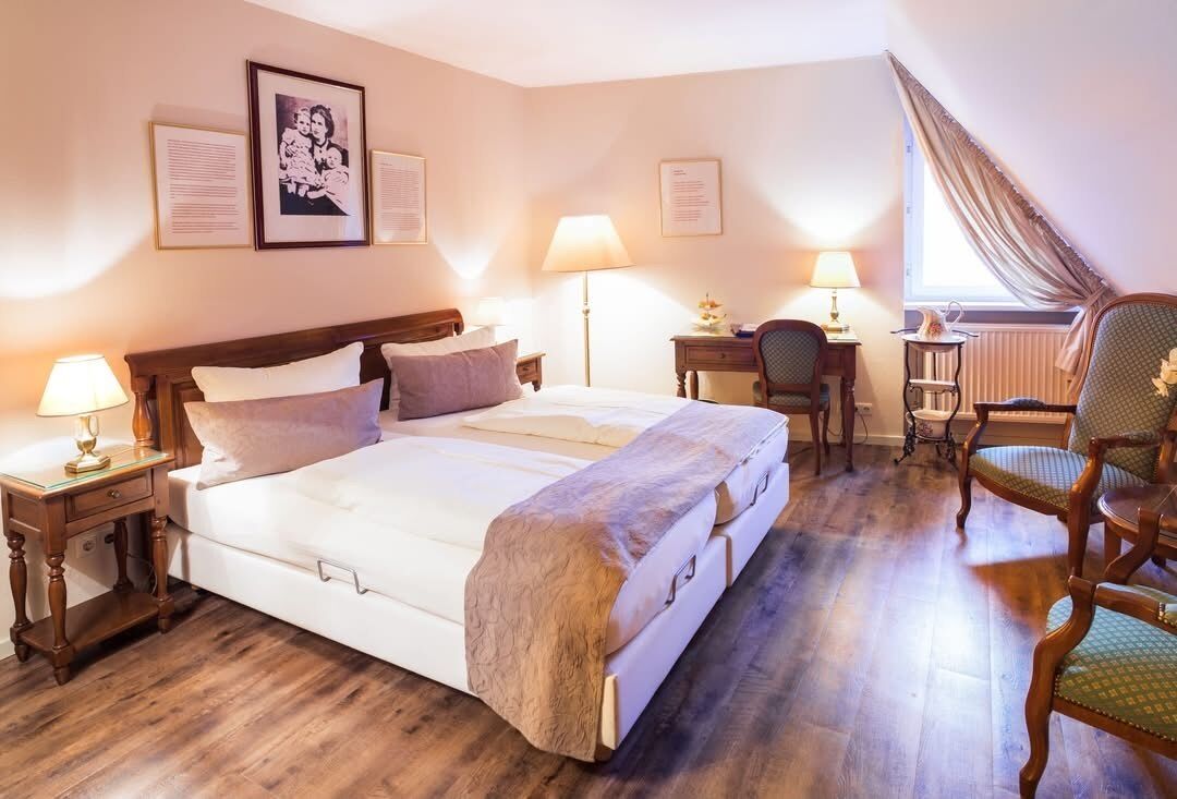 Une chambre d’hôtel avec un grand lit, des tables de chevet, un bureau et une chaise.