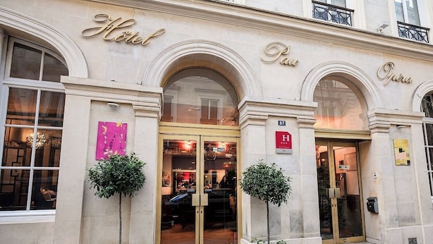 A hotel facade with arched windows, a prominent entrance, and a sign indicating it is a hotel. - Hotel Pax Opera (Paris)