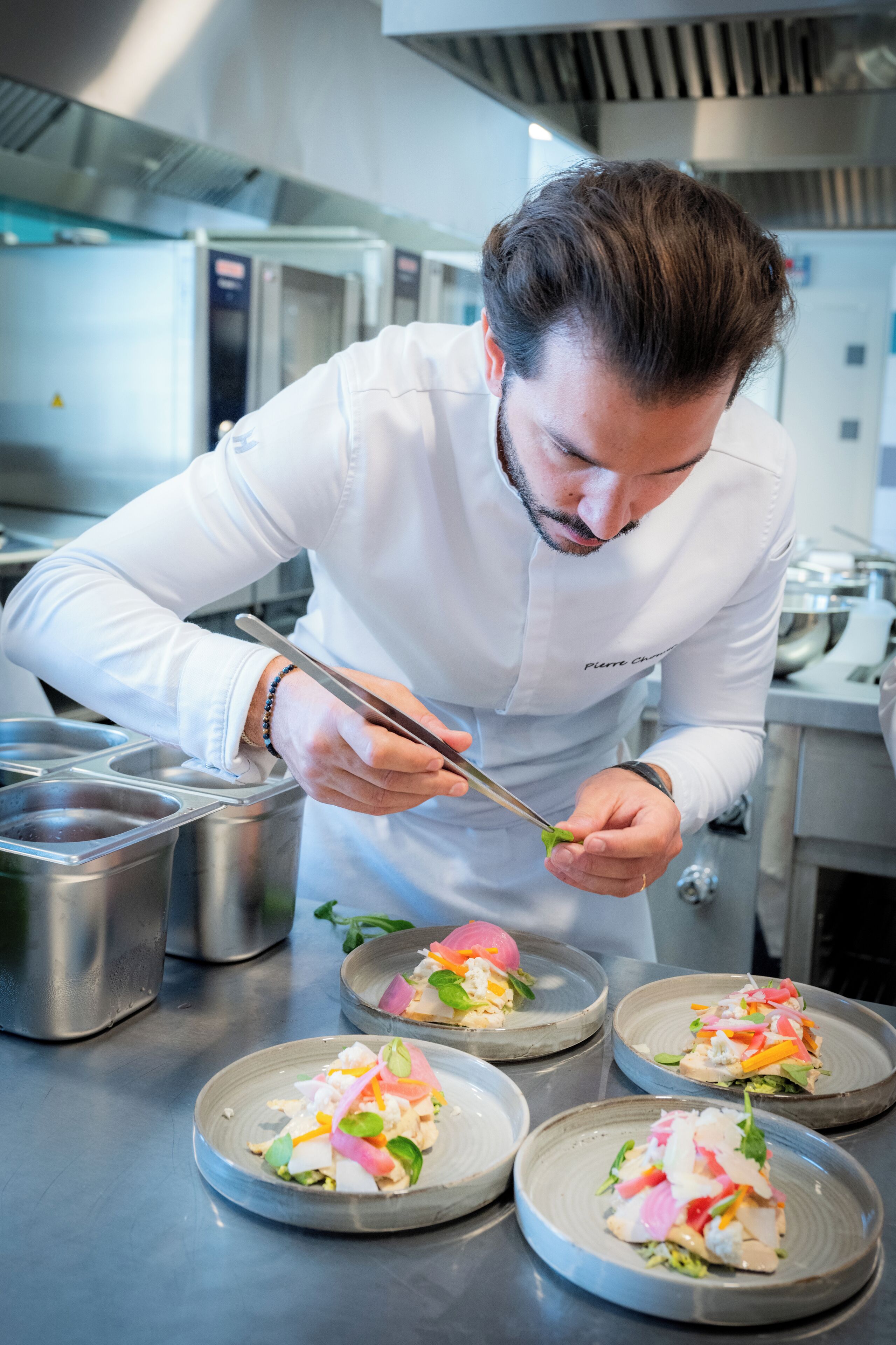 Un chef preparando platos en una cocina profesional.