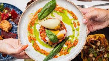 A plate of food with a variety of vegetables and a dollop of sauce.