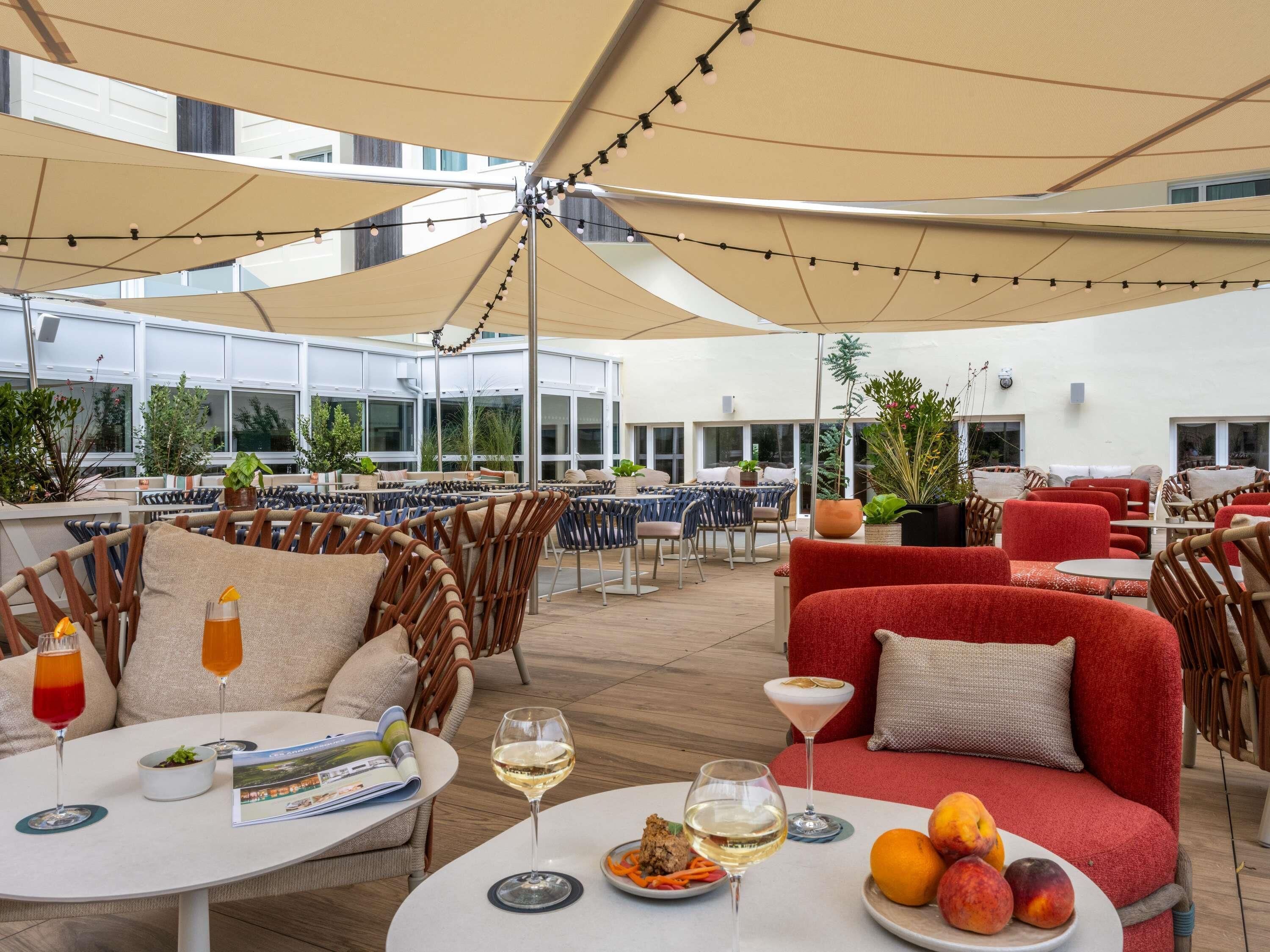 An outdoor dining area with tables, chairs, and umbrellas.