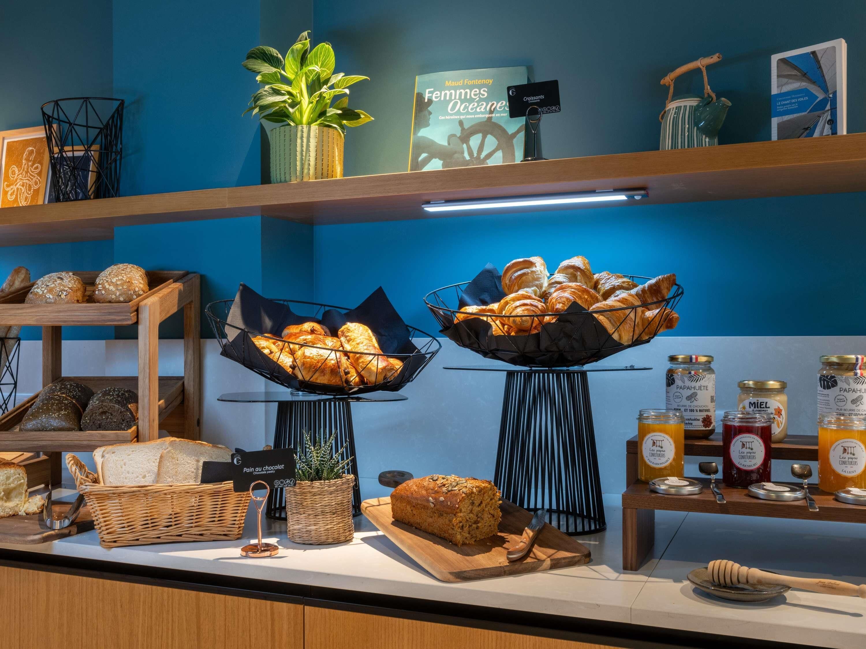 Ein Frühstücksbuffet mit Brot, Gebäck und Honiggläsern.