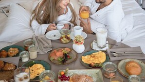 A couple in bed with breakfast spread out on the floor. - Hyatt Regency Mainz (Mainz)