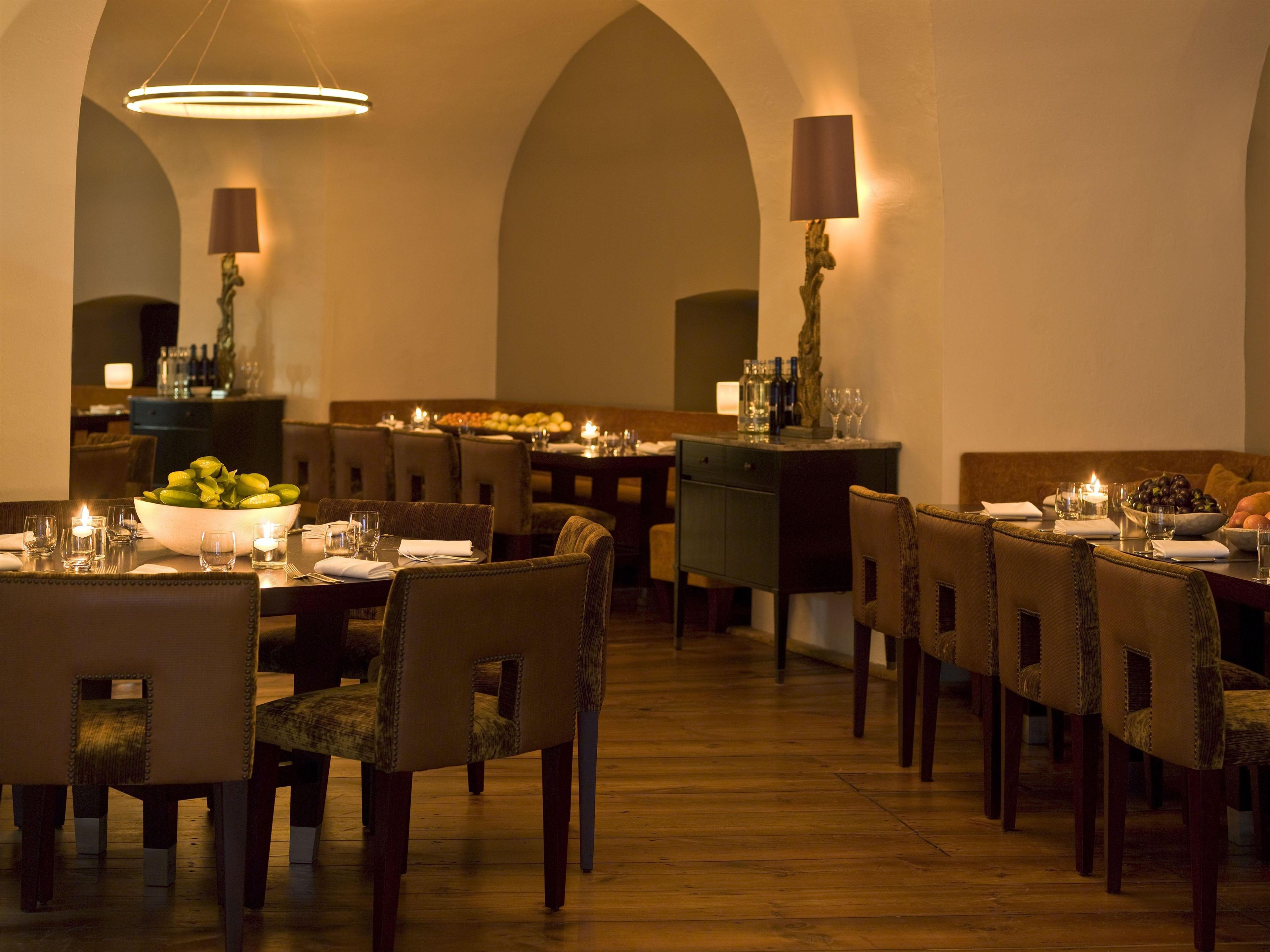 Un restaurant doté d’une longue table à manger, de chaises et d’un lustre.