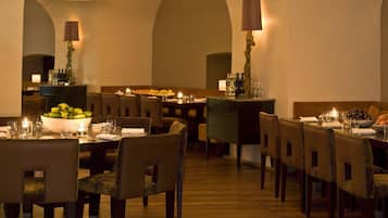 Un restaurant doté d’une longue table à manger, de chaises et d’un lustre.