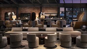 A modern bar area with seating, a bar counter, and a view of the outside.