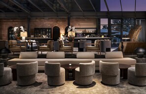 A modern bar area with seating, a bar counter, and a view of the outside.